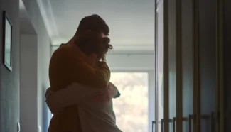 Couple hugging in hallway as they are sad because they suffer from infertility.