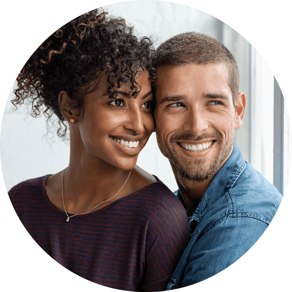 A man and woman smiling joyfully together, standing closely together showing happiness and connection.