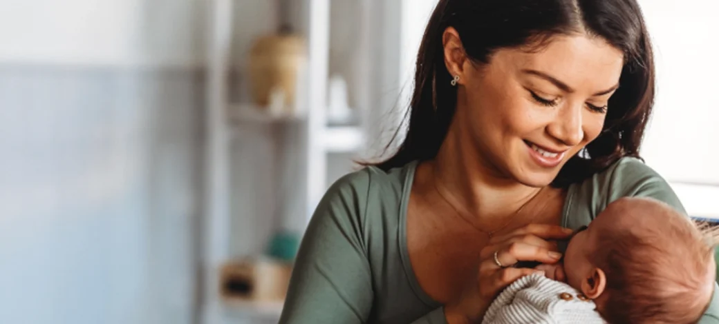 Intended parent looking down at her donor egg conceived baby.