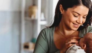 Intended parent looking down at her donor egg conceived baby.